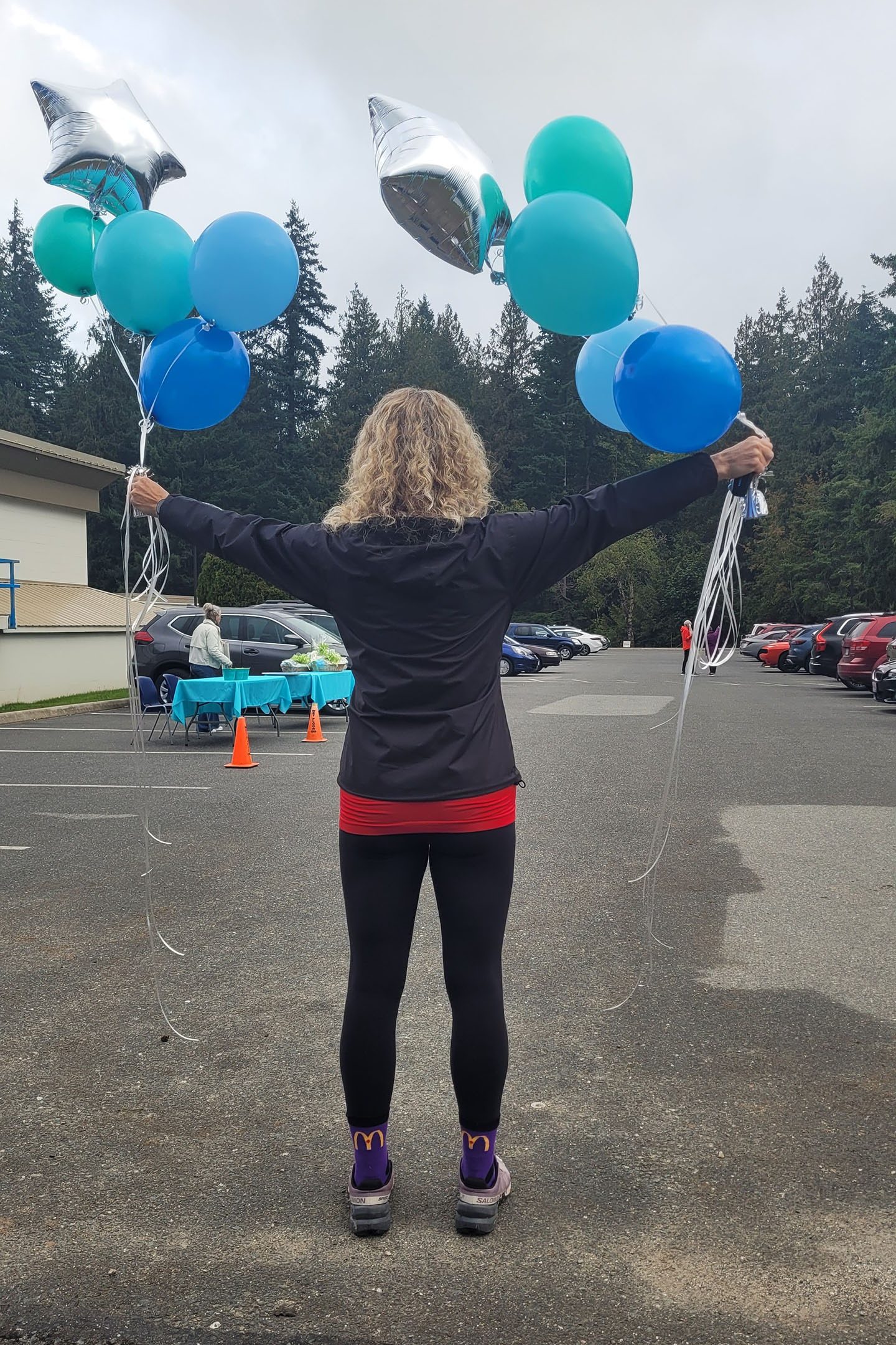 Woman holding up ballo0ns at run/walk event