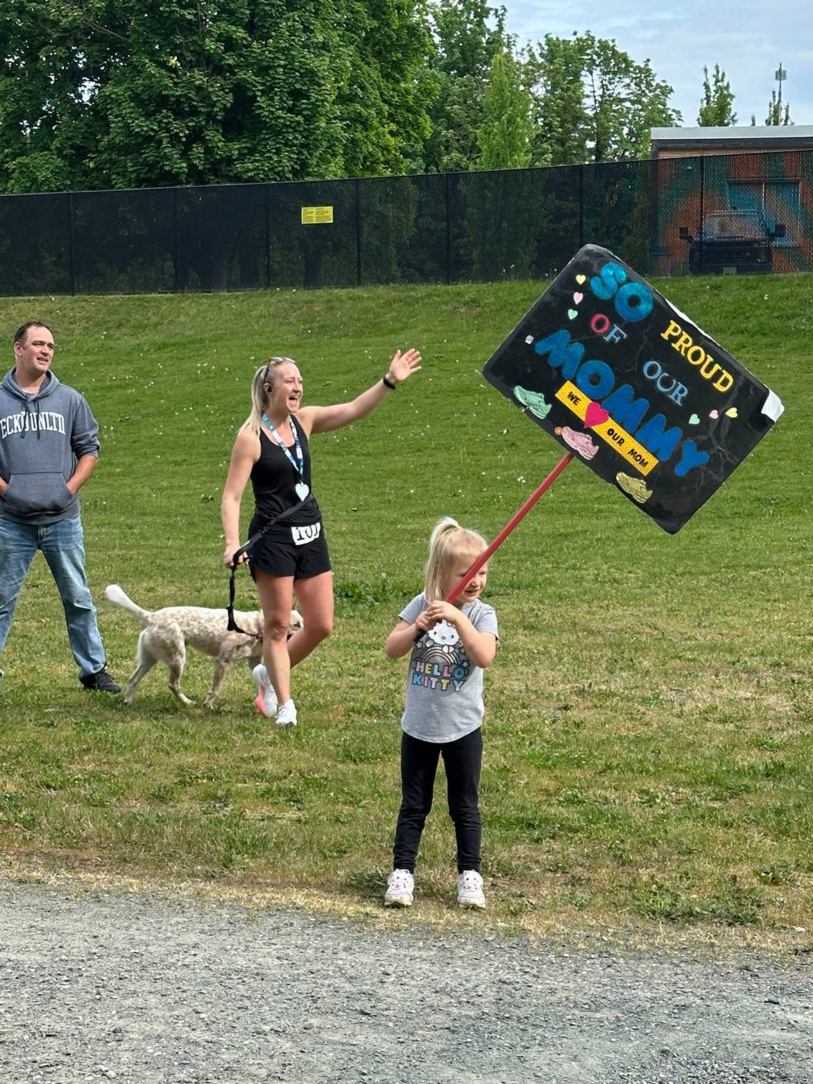 family supporting mother at marathon, child holding up we love mommy banner
