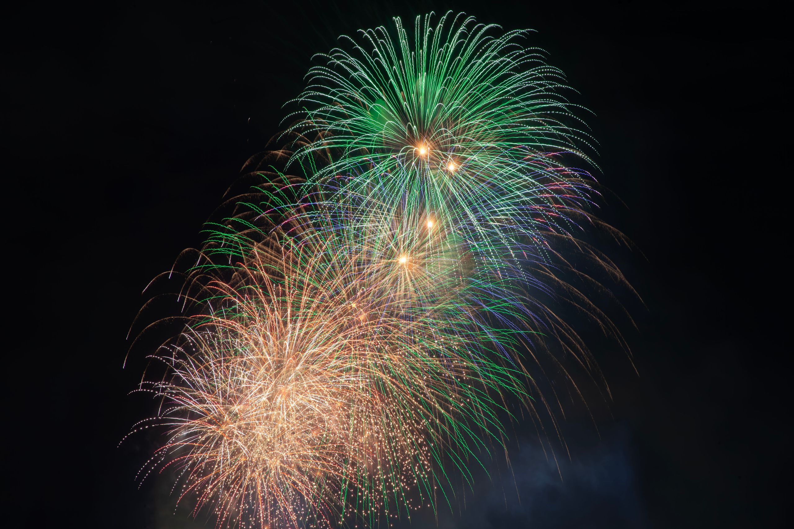 Colorful fireworks burst into the night sky, creating a vibrant and festive display.